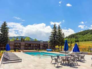 Experience luxury resort living with this stunning outdoor pool area, featuring comfortable lounge chairs and shaded seating perfect for relaxation.