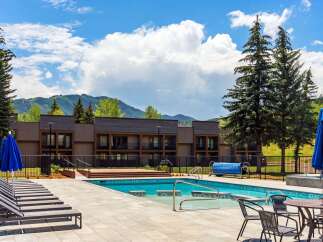 Experience luxury living with this stunning property featuring a sparkling swimming pool and ample lounge chairs perfect for relaxation.