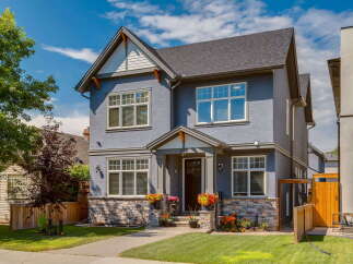 Discover this stunning two-story home featuring a charming blue stucco exterior complemented by stone accents.