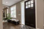 Step into this welcoming entryway featuring a stylish dark wood door with glass panes, complemented by a frosted glass sidelight.