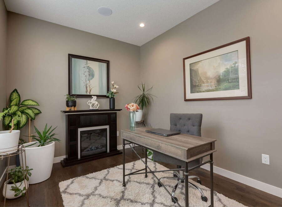 This home office features a cozy electric fireplace, perfect for creating a warm and inviting atmosphere for work or relaxation.