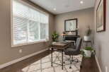 This home office features a large window with blinds, allowing natural light to fill the space.