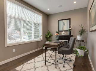 This home office features a large window with blinds, allowing natural light to fill the space.