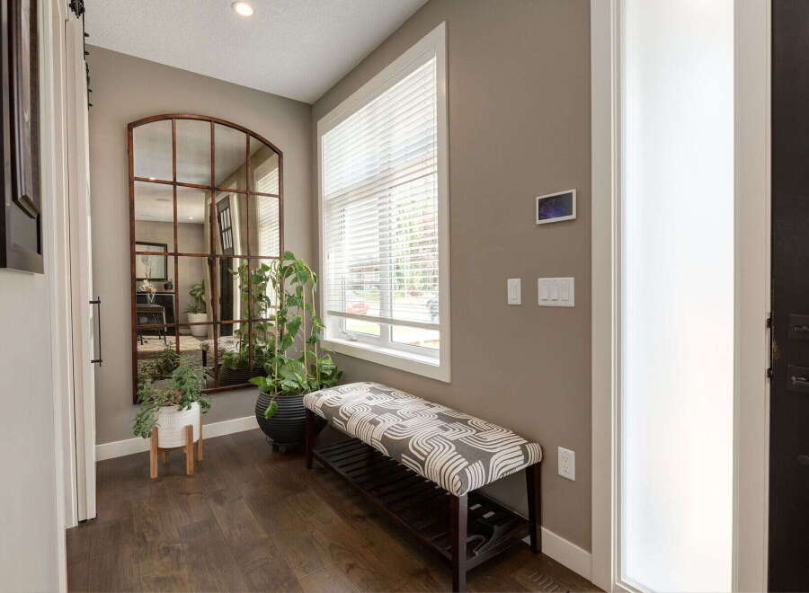 Welcome guests into this inviting entryway featuring a large arched mirror with a rustic metal frame, perfect for last-minute touch-ups.