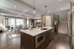 Experience modern living in this open-concept home featuring a gourmet kitchen with a large island, sleek cabinetry, and a built-in microwave.