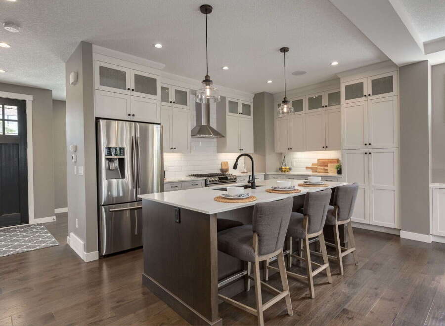 Experience modern luxury in this stunning kitchen, featuring a spacious island with seating, sleek stainless steel appliances, and ample cabinet storage.