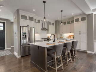 Experience modern luxury in this stunning kitchen, featuring a spacious island with seating, sleek stainless steel appliances, and ample cabinet storage.