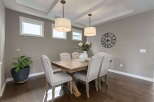 This elegant dining room features a rustic wooden table surrounded by upholstered chairs with nailhead trim.