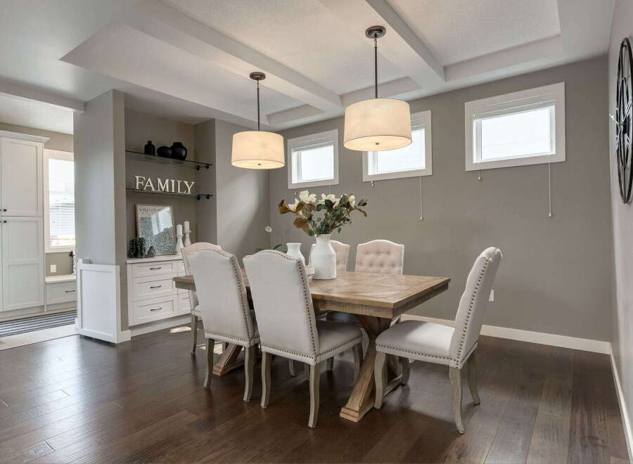 This elegant dining room features a stunning wooden table surrounded by upholstered chairs, perfect for hosting gatherings.