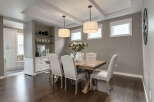 This elegant dining room features a stunning wooden table surrounded by upholstered chairs, perfect for hosting gatherings.
