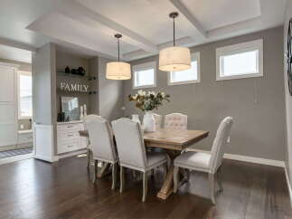 This elegant dining room features a stunning wooden table surrounded by upholstered chairs, perfect for hosting gatherings.