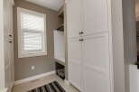 This laundry room features ample storage with tall white cabinets and a built-in dog washing station.
