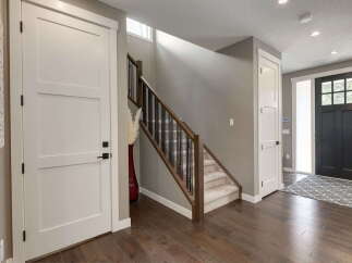 Step into this inviting entryway featuring a modern staircase with dark wood railings and sleek black spindles.