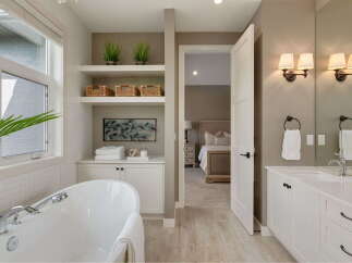Experience luxury in this stunning bathroom featuring a freestanding soaking tub and a spacious vanity with dual sinks.