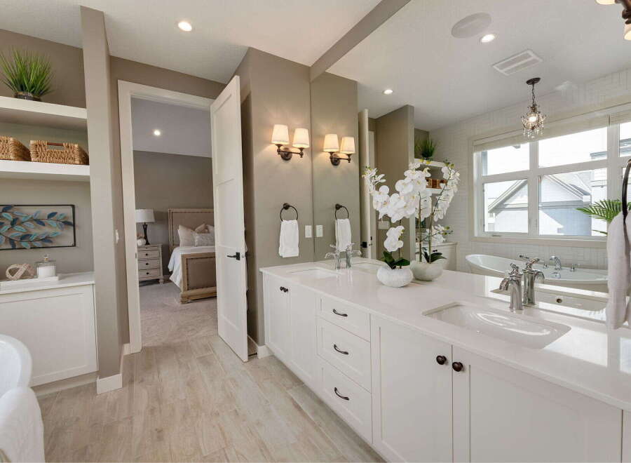Experience luxury in this stunning master bathroom, featuring a spacious double vanity with sleek white countertops and modern fixtures.