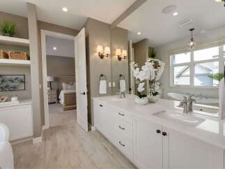Experience luxury in this stunning master bathroom, featuring a spacious double vanity with sleek white countertops and modern fixtures.