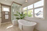 Experience luxury in this stunning bathroom featuring a freestanding soaking tub and a spacious glass-enclosed shower.