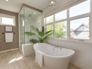 Experience luxury in this stunning bathroom featuring a freestanding soaking tub and a spacious glass-enclosed shower.