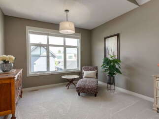 This inviting room features a large window that floods the space with natural light, highlighting the plush carpeting and elegant decor.