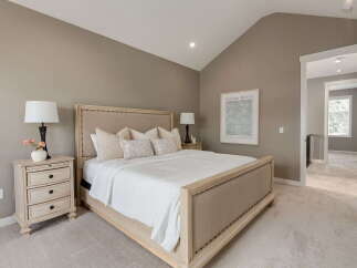 Experience ultimate comfort in this serene bedroom, featuring a plush king-size bed adorned with soft linens and decorative pillows.