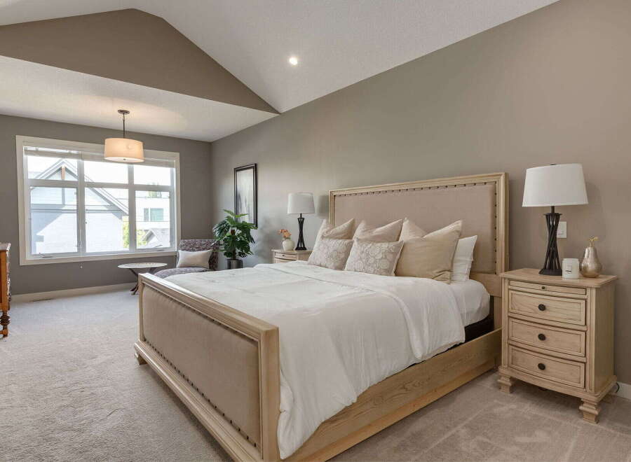 Experience ultimate comfort in this serene master bedroom, featuring a plush king-size bed with a tufted headboard and soft, neutral-toned linens.
