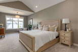 Experience ultimate comfort in this serene master bedroom, featuring a plush king-size bed with a tufted headboard and soft, neutral-toned linens.