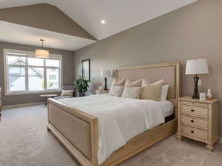 Experience ultimate comfort in this serene master bedroom, featuring a plush king-size bed with a tufted headboard and soft, neutral-toned linens.