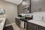 Discover this modern kitchen featuring sleek, dark wood cabinetry and a stainless steel microwave.
