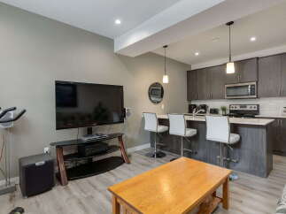 Experience modern living in this open-concept condo featuring a sleek kitchen with stainless steel appliances and a breakfast bar perfect for casual dining.