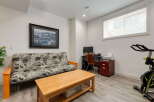 This versatile room features a comfortable futon, perfect for guests or lounging, alongside a functional workspace with a desk, computer, and printer.
