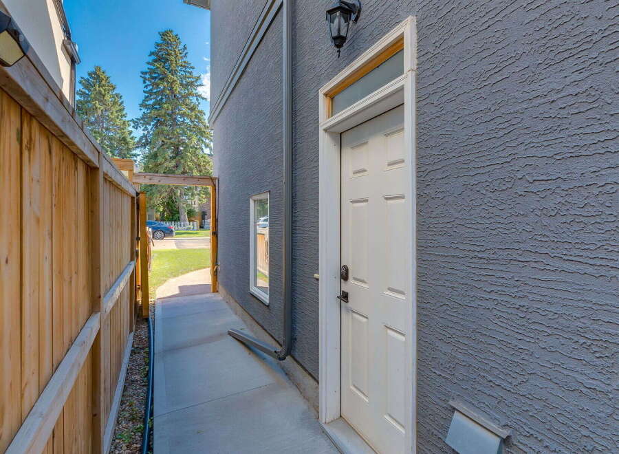 Discover this charming property featuring a private wooden fence leading to a side entrance.