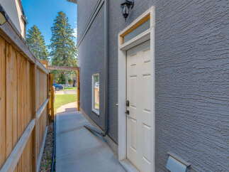 Discover this charming property featuring a private wooden fence leading to a side entrance.