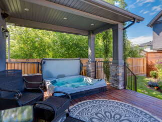 Enjoy ultimate relaxation in this covered backyard oasis, featuring a luxurious hot tub perfect for unwinding.
