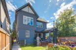 Discover this stunning modern home featuring a sleek dark blue exterior and a spacious backyard perfect for entertaining.