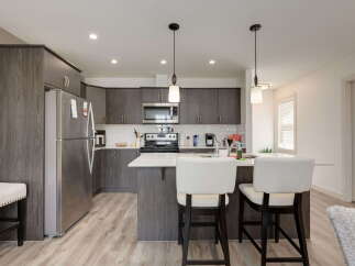 Discover this modern kitchen featuring sleek, dark wood cabinetry and a spacious island perfect for casual dining or entertaining.