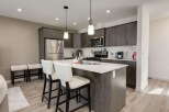 Discover this modern kitchen featuring sleek dark wood cabinetry and a spacious quartz island perfect for meal prep and casual dining.