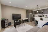 Experience modern living in this stylish open-concept space, featuring a sleek kitchen with stainless steel appliances and ample cabinet storage.