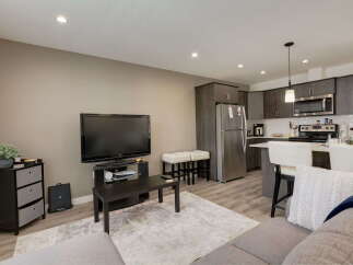 Experience modern living in this stylish open-concept space, featuring a sleek kitchen with stainless steel appliances and ample cabinet storage.