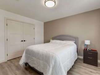 Discover comfort and style in this inviting bedroom, featuring a plush queen-size bed with a tufted headboard perfect for relaxation.