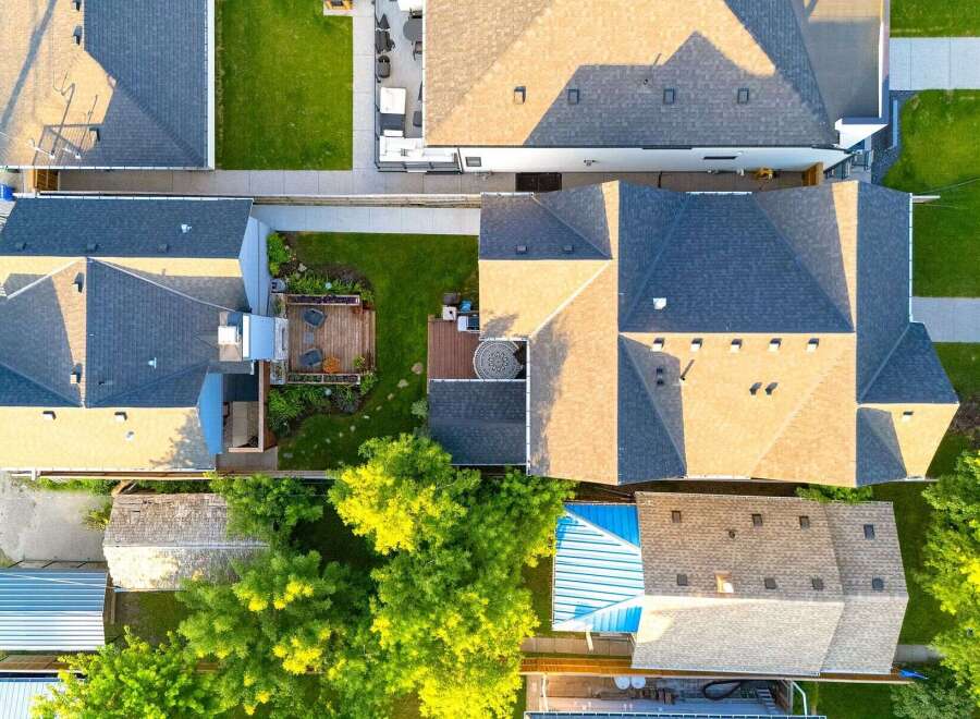 Discover this stunning aerial view showcasing a beautifully maintained property with multiple dwellings and lush green spaces.