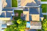 Discover this stunning aerial view showcasing a beautifully maintained property with multiple dwellings and lush green spaces.