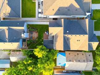 Discover this stunning aerial view showcasing a beautifully maintained property with multiple dwellings and lush green spaces.