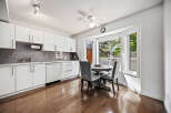 Bright and modern kitchen featuring sleek white cabinetry, a stylish grey subway tile backsplash, and a charming breakfast nook.