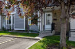 Discover this charming townhouse featuring a welcoming entrance with a paved walkway and steps leading to the front door.