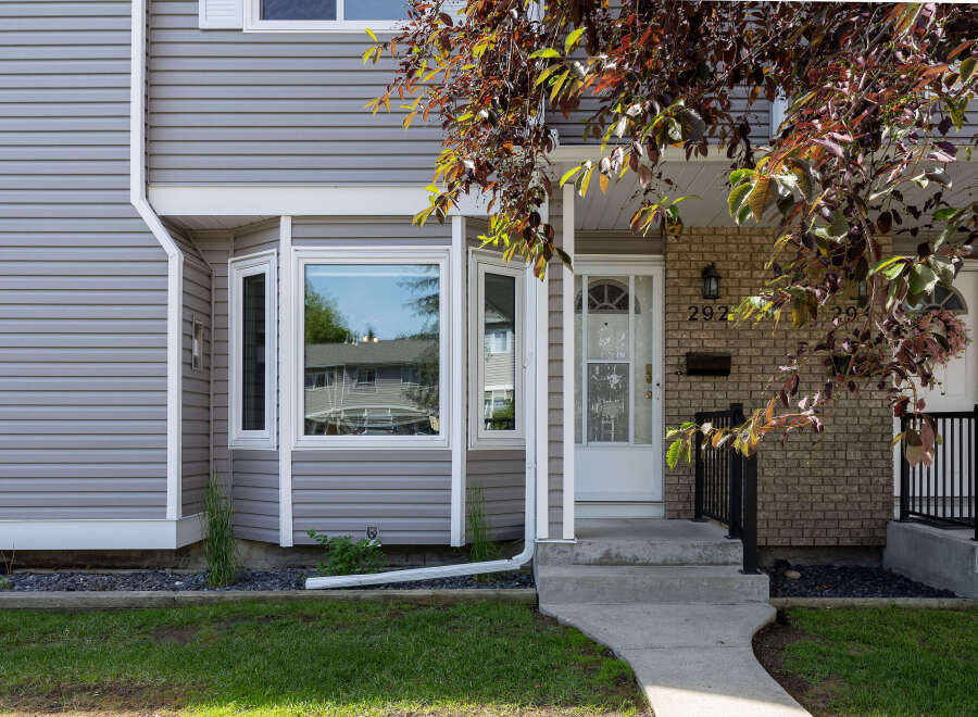 Charming home featuring a welcoming front entrance with a white door and a decorative transom window.