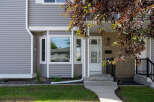 Charming home featuring a welcoming front entrance with a white door and a decorative transom window.