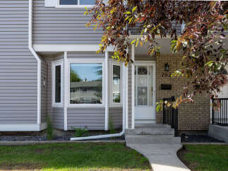 Charming home featuring a welcoming front entrance with a white door and a decorative transom window.