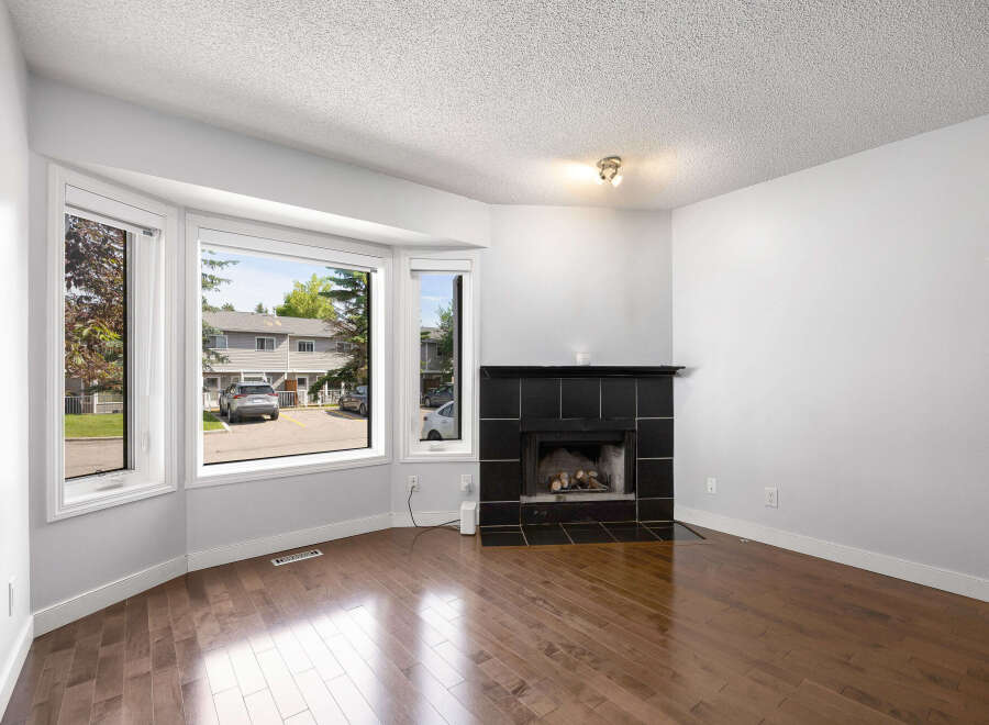Step into this inviting living room featuring a cozy fireplace with a sleek black tile surround, perfect for chilly evenings.