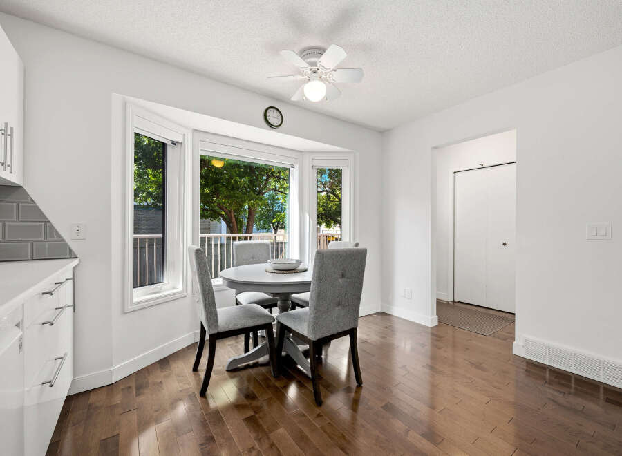 Bright and airy dining area featuring a charming bay window with lush green views.
