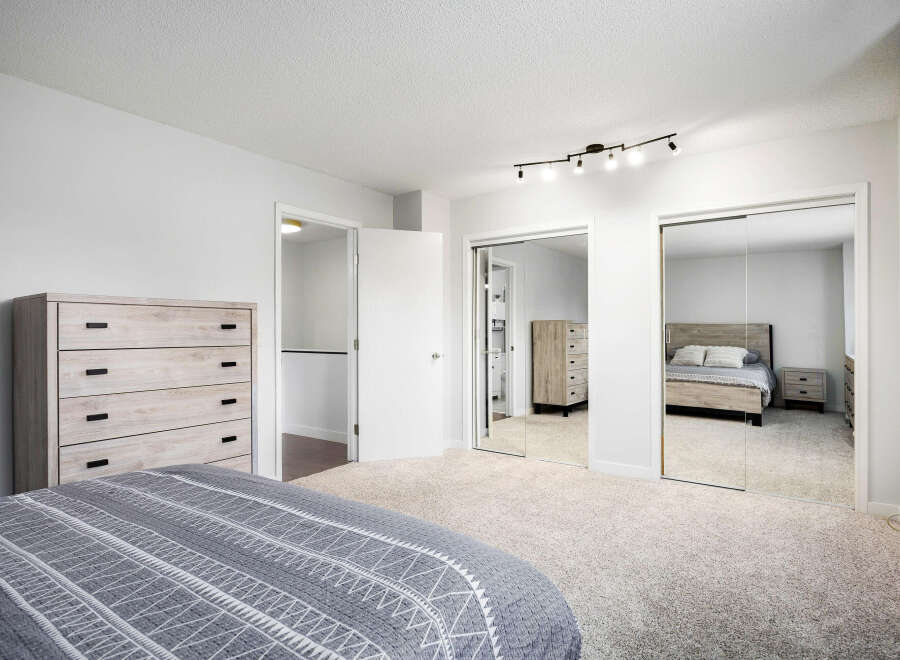 Discover this spacious master bedroom featuring a large dresser and ample closet space with mirrored sliding doors.